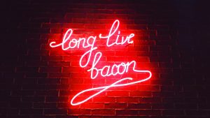 red-ling-live-bacon-neon-light-signage-on-brown-wa by .