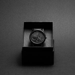 round-black-chronograph-watch-in-case by .