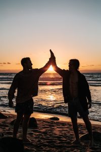 two-men-clapping-each-other-on-shore by .